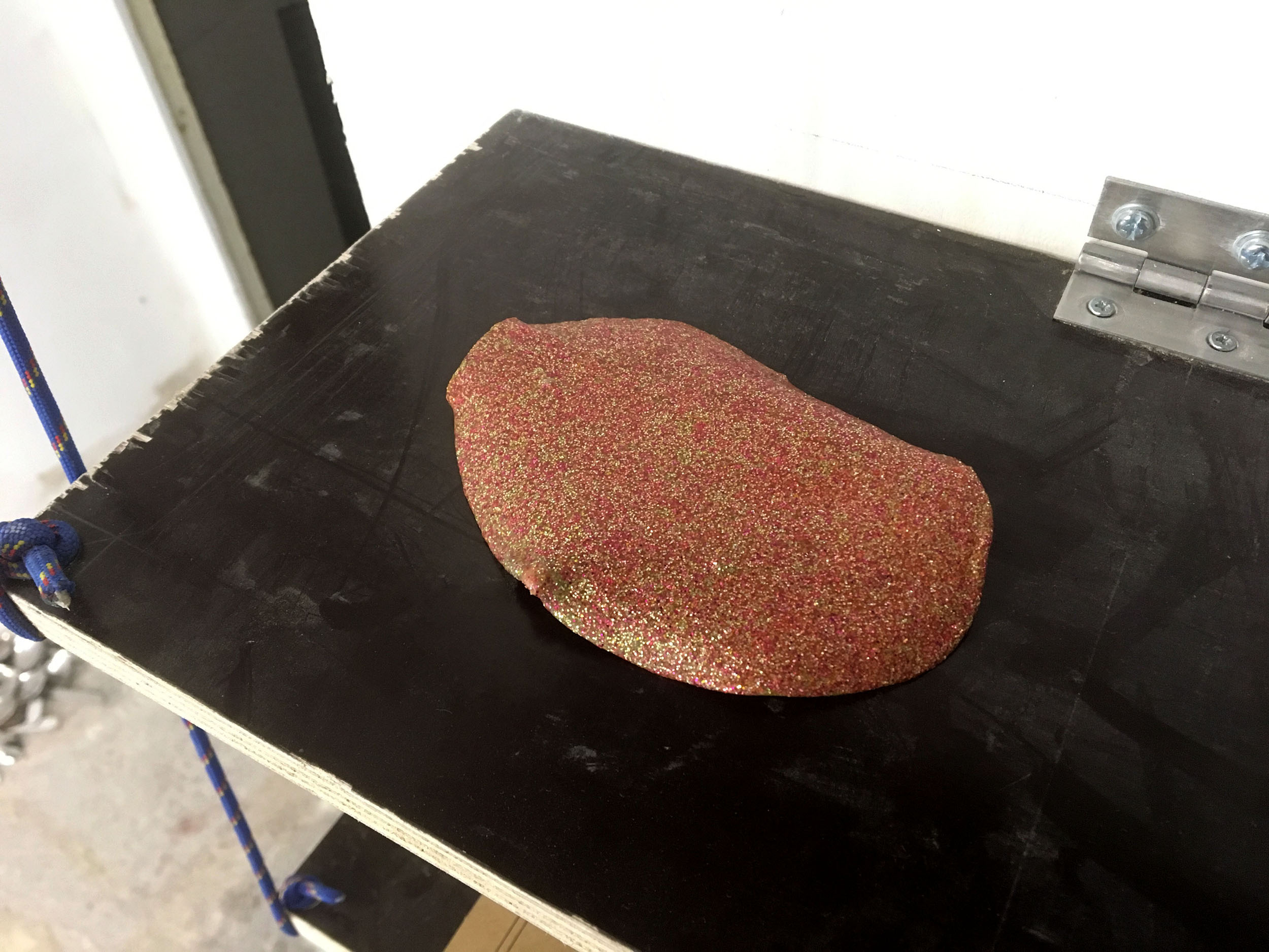 Un slime séché à paillette est psoé sur une étagère.